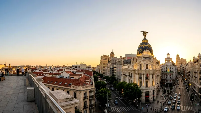 Metrópolis Building dome on Gran Vía at golden hour under a clear sky